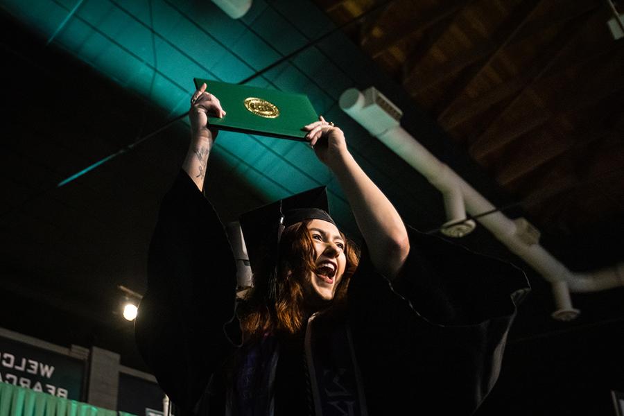 周六，<a href='http://sm3r.qfyx100.com'>澳门网上博彩官方网站</a>的一名毕业生在毕业典礼上展示她的毕业证书.